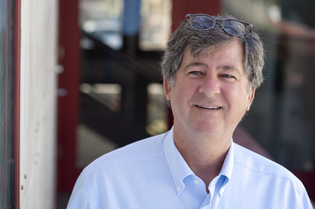 A man with grey hair and a white shirt